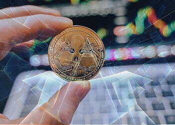 A person holding a digital coin XRP.